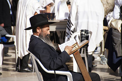 Jewish man reading the book of Psalms at the Western Wall